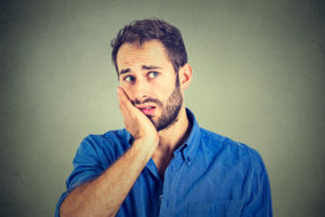 No motivation in life. Sad worried man isolated on gray wall background