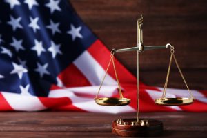 scales of justice and the Flag of the United States of America